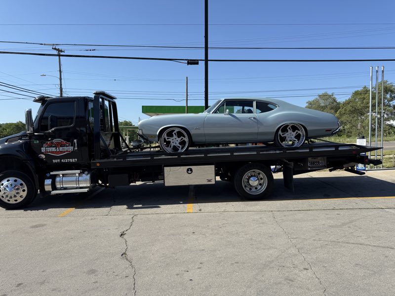 RR Towing & Recovery flatbed loaded with a classic silver Oldsmobile 442 on chrome wheels